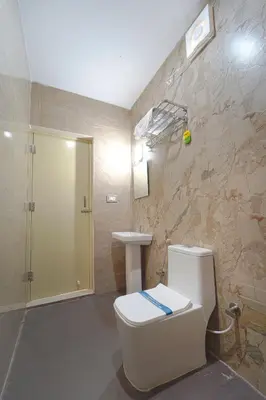 a bathroom with a toilet and a sink at Estoria Hotel and Resort in Kadakola