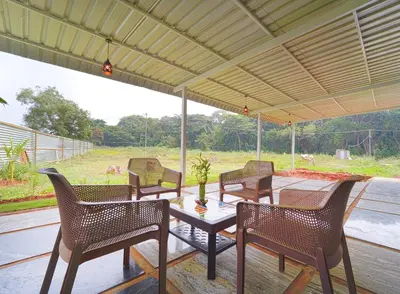 a group of chairs and a table on a patio at Estoria Hotel and Resort in Kadakola