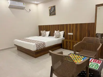 a bedroom with a bed and a table and chairs at Estoria Hotel and Resort in Kadakola