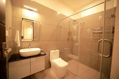 a bathroom with a toilet and a sink and a shower at LUMARISE Premium Wayanad Business Hotel in Sultan Bathery