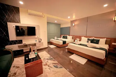 a hotel room with two beds and a flat screen tv at LUMARISE Premium Wayanad Business Hotel in Sultan Bathery