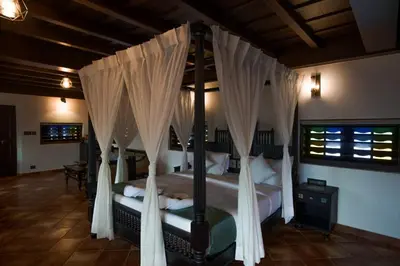 a bedroom with a canopy bed with white curtains at SVS Arena in Kodali