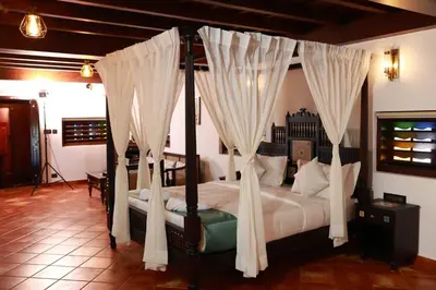 a bedroom with a canopy bed with white curtains at SVS Arena in Kodali