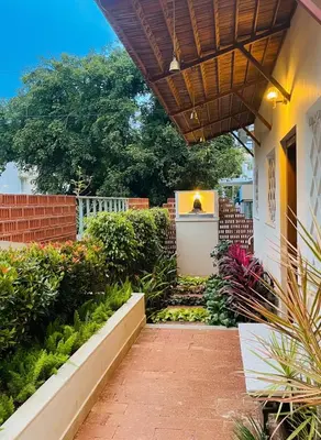 a walkway leading to a house with a garden at Nesara Home Stay Mysuru in Mysore