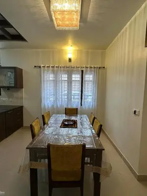 a dining room with a long table and chairs at Villa Vinaya- Comfort, Calm & Charm in Mysore in Mysore
