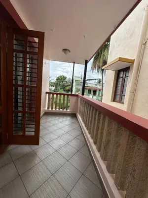 a balcony of a house with a wooden door at Villa Vinaya- Comfort, Calm & Charm in Mysore in Mysore