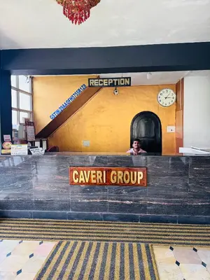 a person sitting at a counter in a train station at Hotel caveri comfort in Madikeri