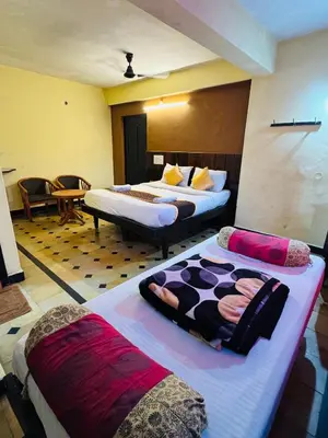 a hotel room with two beds in a room at Hotel caveri comfort in Madikeri