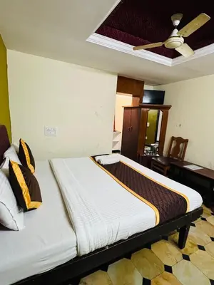 a bed in a room with a ceiling at Hotel caveri comfort in Madikeri