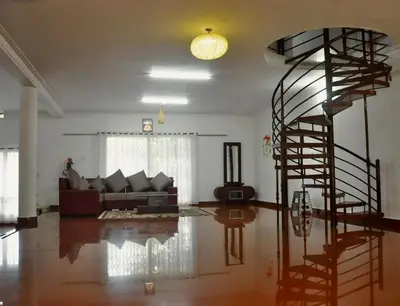 a living room with a spiral staircase in a house at Coorg River Song Homestay in Kushālnagar