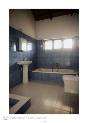 a bathroom with a tub and a sink and a toilet at Coorg River Song Homestay in Kushālnagar