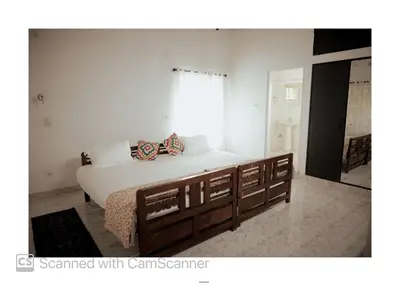 a bedroom with a large bed and a window at Coorg River Song Homestay in Kushālnagar