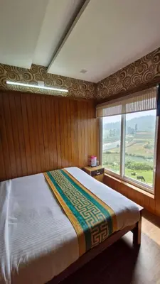 a bedroom with a large bed with a large window at Meadows mist ooty in Ooty