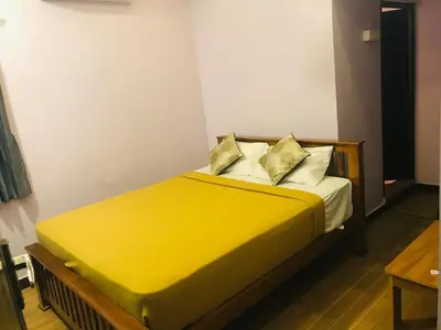 a bed with yellow sheets and pillows in a room at Padma residency in Coimbatore