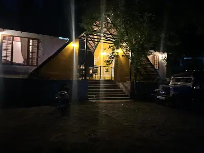 a house with stairs leading to a door at night at Kanthalloor puregolds in Kanthalloor