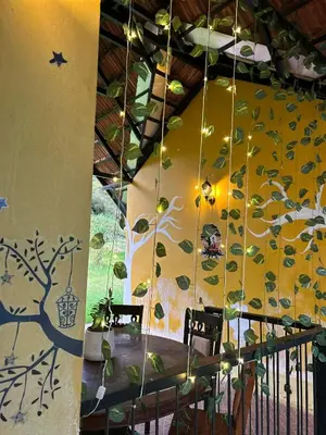 a dining room with a tree mural on the wall at Kanthalloor puregolds in Kanthalloor