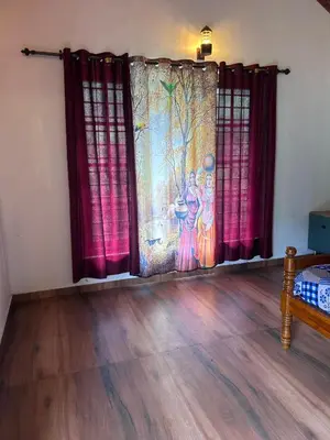 a living room with curtains and a wooden floor at Kanthalloor puregolds in Kanthalloor