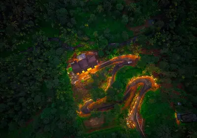 an aerial view of a house with lights on a road at Achutham Cottages Wayanad by VOYE HOMES in Padinjarathara