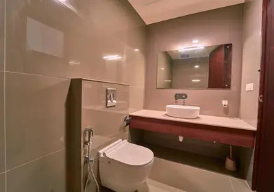 a bathroom with a toilet and a sink at Achutham Cottages Wayanad by VOYE HOMES in Padinjarathara