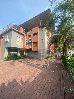a building with a palm tree in front of it at Neurogreen Apartments in Kottakkal