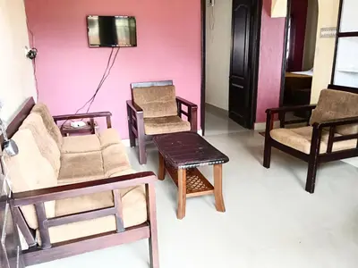 a room with chairs and a couch and a tv at Coorg villas & homes in Madikeri