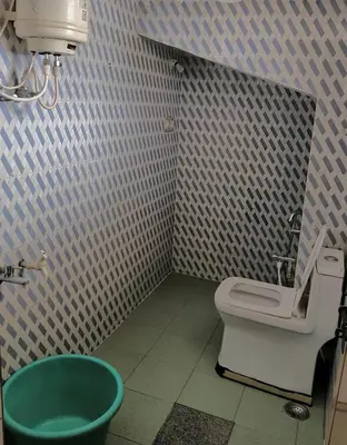a bathroom with a toilet and a green tub at Coorg villas & homes in Madikeri