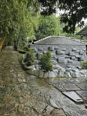 a stone wall with some plants in a yard at Rendezvous Jungle Resort in Sultan Bathery