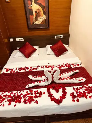 a bed with red rose petals on it at Rendezvous Jungle Resort in Sultan Bathery