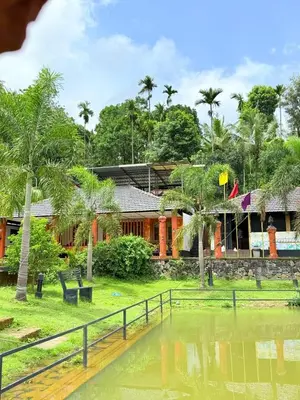a house with a pond in front of it at Rendezvous Jungle Resort in Sultan Bathery
