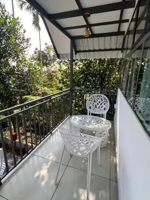 a patio with two chairs and a table on a balcony at Nefs Dreams Villa in Vaduvanchal