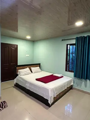 a bedroom with a bed with a red blanket on it at Nefs Dreams Villa in Vaduvanchal