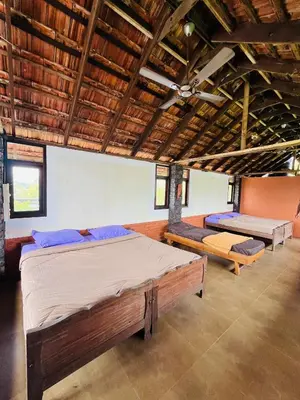 a large room with two beds and a ceiling at Kottaram Heritage in Pallipuram