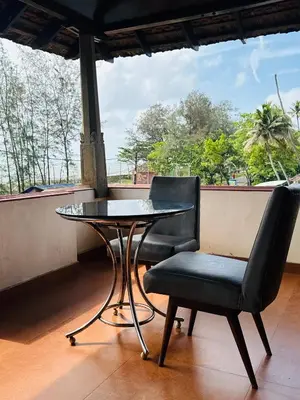 a table and two chairs sitting next to a table at Kottaram Heritage in Pallipuram