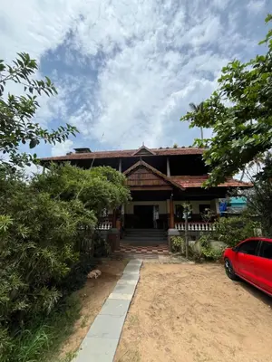 a house with a red car parked in front of it at Kottaram Heritage in Pallipuram