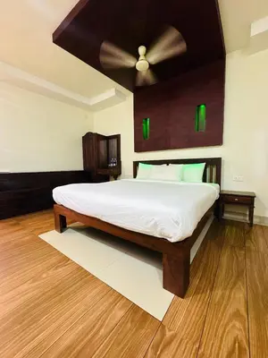a bedroom with a bed with a ceiling fan at Kottaram Heritage in Pallipuram