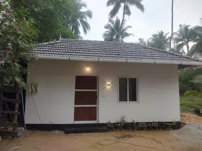 a small white house with a window and a door at Katadi beach coral cottage in Thanniyam