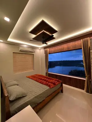 a bedroom with a bed and a large window at Kvm RIVER VIEW - 2bhk in Palakkad