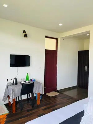 a room with two tables and a tv on the wall at Bison valley resort Anikorai in Ooty