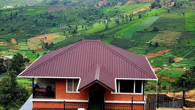 a house with a red roof with a view of a mountain at Bison valley resort Anikorai in Ooty