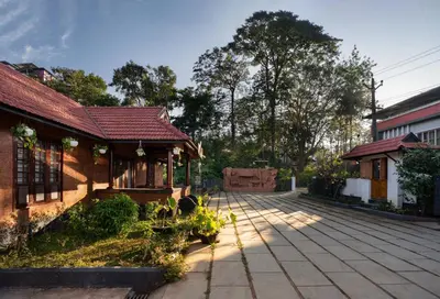 a house with a red roof and a courtyard at Punarjeevani Ayurvedic Heritage in Vythiri