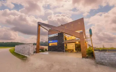 a house with a large window on the side of it at FabHotel Sholas Residency I - Nr Government Rose Garden in Ooty