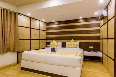 a bedroom with a large white bed and a desk at FabHotel Sholas Residency I - Nr Government Rose Garden in Ooty
