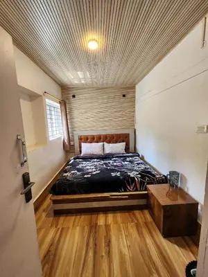 a bedroom with a bed in the middle of a room at Wings Cottage in Ooty