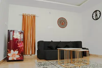 a living room with a black couch and gold tables at Chestnut Villa in Wayanad