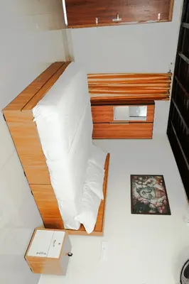 a bed in a small room with white sheets at Chestnut Villa in Wayanad