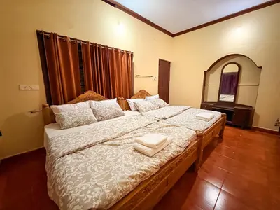 a bedroom with a large bed with two towels on it at KOORGI RETREAT- Coorg in Napoklu