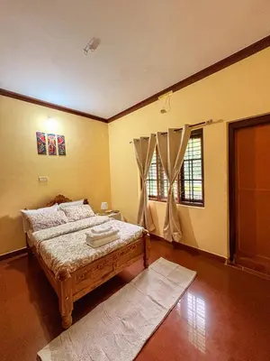 a bedroom with a bed and a window at KOORGI RETREAT- Coorg in Napoklu