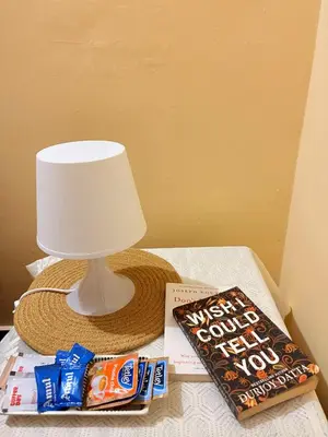 a table with a lamp and a book and a hat at KOORGI RETREAT- Coorg in Napoklu