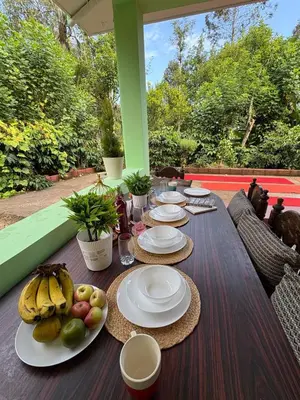 a wooden table with plates of fruit on it at KOORGI RETREAT- Coorg in Napoklu