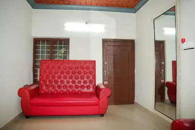 a red chair in a room with a mirror at Dua farms in Sultan Bathery